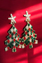 Festive holiday tree earrings with colorful gem stars on a red background, perfect for Christmas outfits.