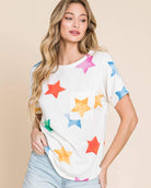 Model wearing TA2022 Soft Knit T-Shirt with colorful stars design, paired with denim shorts for a casual look.