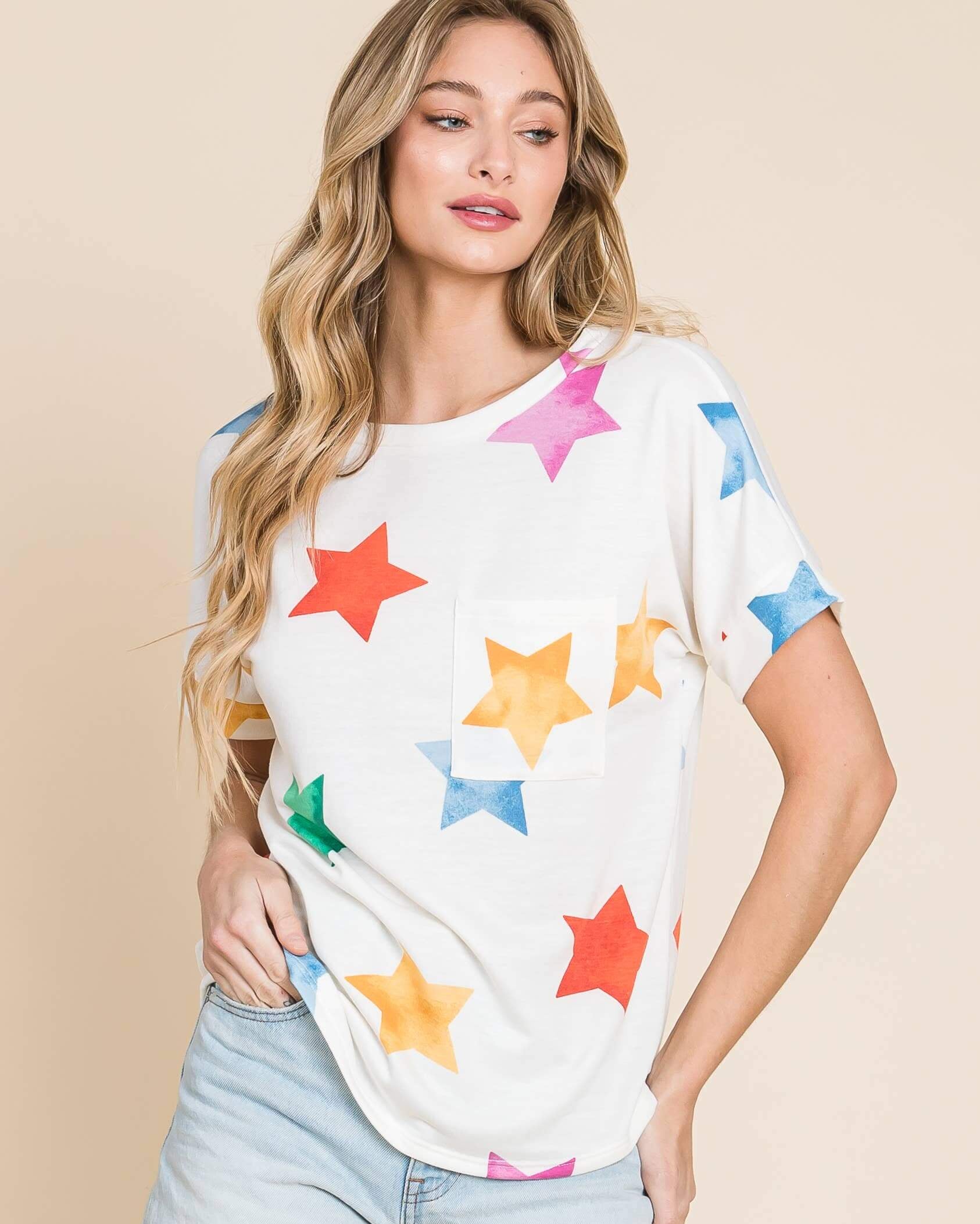Model wearing TA2022 Soft Knit T-Shirt with colorful stars design, paired with denim shorts for a casual look.