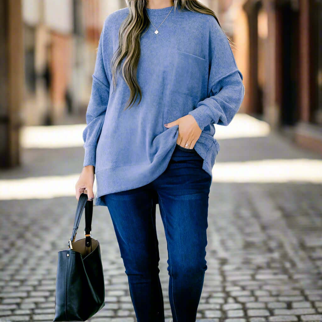 A woman wearing a light blue sweater and jeans, showcasing the CLOUDY SKY - ZENANA outfit in a stylish outdoor setting.