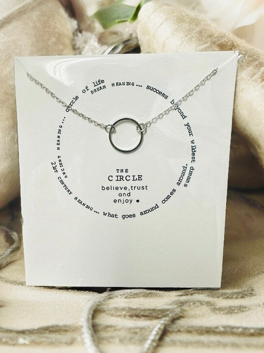 Silver-toned necklace featuring a pendant with the uplifting quote 'The Circle' on a stylish display.