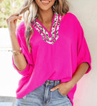 FIERCE FOCUS TOP (pink) featuring bold leopard patchwork trim and flattering V-neckline in a vibrant pink blouse.