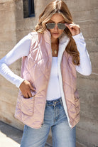 Woman wearing REVERSIBLE RETREAT VEST! in pink, showcasing trendy quilted design and cozy sherpa lining.