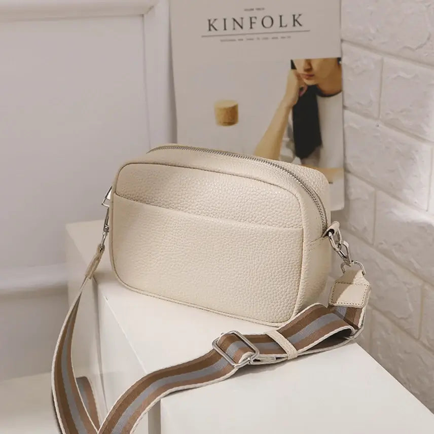 Beige SAMANTHA Crossbody Bag with Montana West strap on white table, featuring sleek PU leather design and adjustable strap.