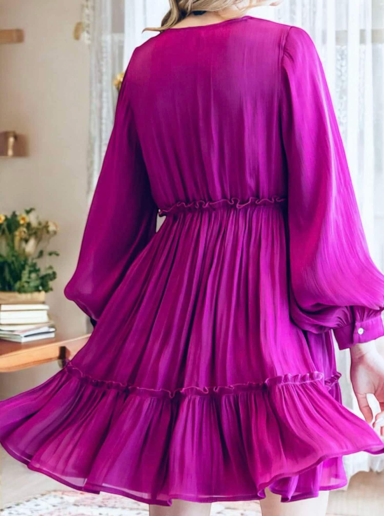 Woman wearing Bermuda Beauty Dress in magenta with balloon sleeves and v-neckline, showcasing crinkle shimmery fabric.