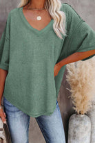 Model showcasing the Carefree Mode Top in jade green, featuring a V-neckline, relaxed fit, and breathable textured knit.