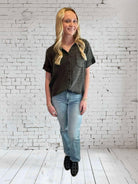 Model wearing MIDNIGHT MIST top by Umgee, featuring a V neckline and frayed hem, paired with light jeans.