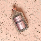 Petal-Infused Effervescent Mineral Bath Salts (Duo Pack) in a jar with lavender on a pink background.