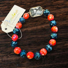 Pomina Level Up bracelet with fiery red and smoke beads, featuring a rectangular glass gemstone with gold tone edge.