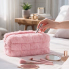 COTTON CANDY CRUSH MAKEUP CASE on a bed with makeup essentials, featuring plush faux fur and a cozy design.