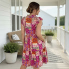 STATEMENT PIECE DRESS - Dear Scarlett on a woman, showcasing vibrant patchwork floral print in pinks and warm tones.
