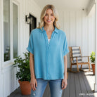 Model wearing CALMING COAST TOP - Umgee in aqua, styled with a relaxed silhouette, perfect for casual wear.