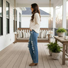 Woman wearing JUDY BLUE - ADDISION JEANS on a porch, showcasing high rise distressed straight leg design.