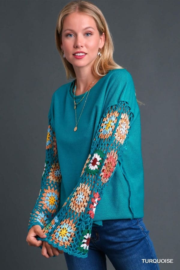 Woman wearing Flower Child Crochet Sleeve Top with colorful crochet details on sleeves, turquoise color, French Terry fabric.