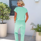 WEEKEND REWIND 2 PIECE SET (MINT) worn from behind, showcasing its relaxed fit and stylish design in a sunny outdoor setting.