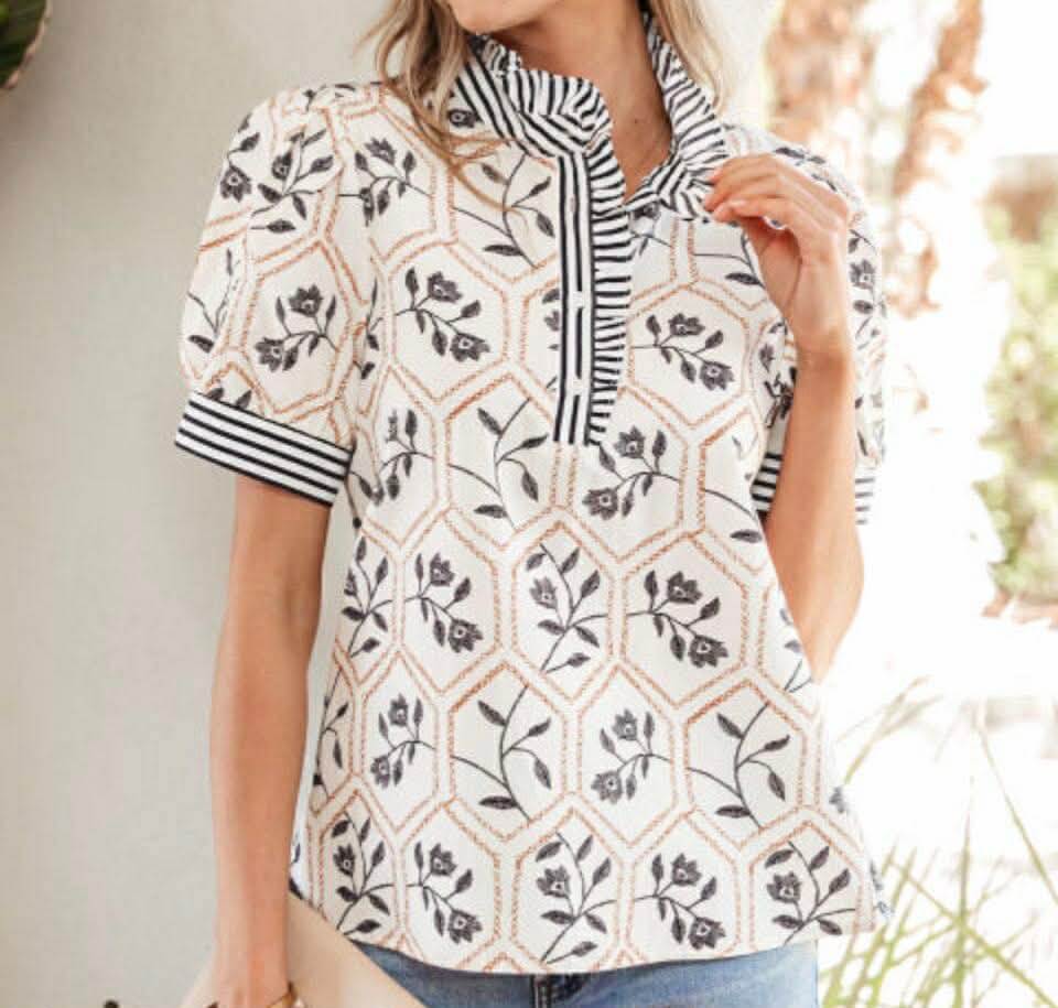 Model wearing CHOOSE JOY TOP featuring floral and geometric prints with a ruffled neckline and puff sleeves.