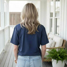 LULU MAC ALL AMERICAN COMFORT COLOR TEE worn by a woman, showcasing the navy color and relaxed fit from behind.