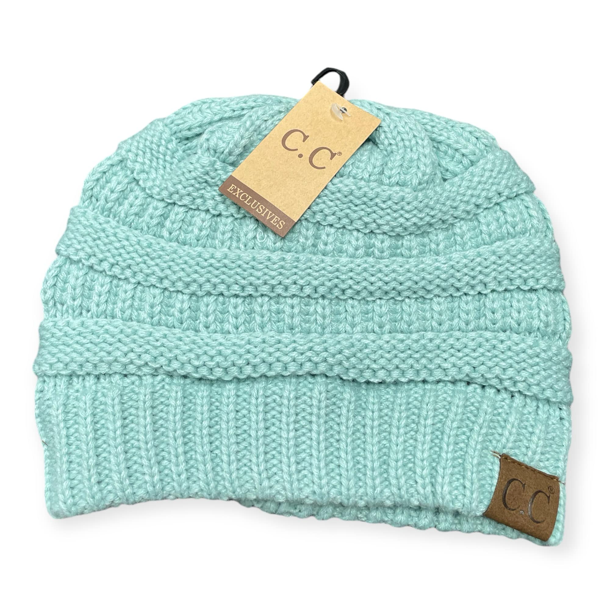 Teal knit beanie by C.C. with suede patch, showcasing cozy and stylish winter fashion.