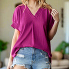 Magenta Bright Side Beauty top with V neckline, short sleeves, and relaxed fit, paired with denim shorts.