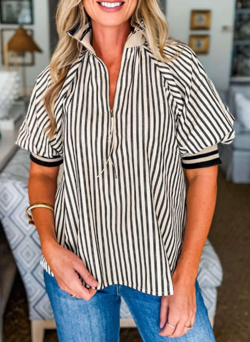 Model wearing the CLASSIC CURRENT TOP with black and white stripes, half zip neckline, and soft puff sleeves.