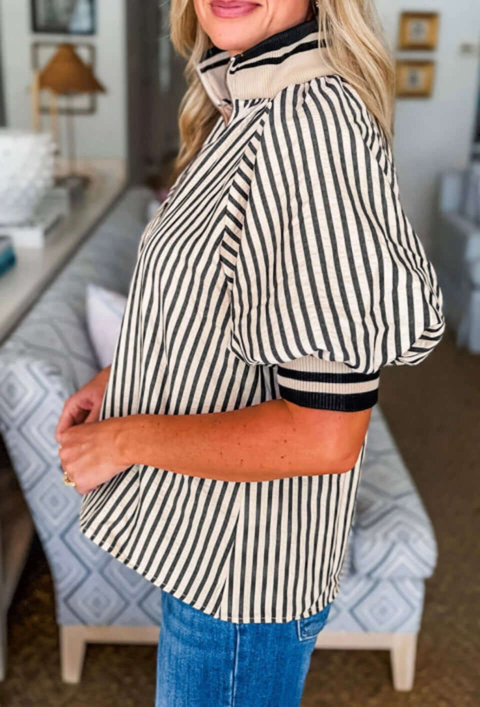 Woman wearing CLASSIC CURRENT TOP with black stripes and soft puff sleeves, stylish and chic.