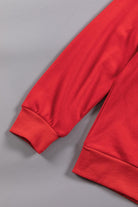 Red crewneck sweatshirt sleeve detail showcasing cozy fabric and stylish fit.