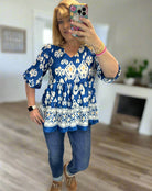 Model wearing the Follow The Music Boho Chic V-Neck Blouse in cobalt blue with white and peach accents.