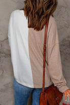 Back view of a woman wearing a cozy colorblock knit top with long sleeves and casual style.