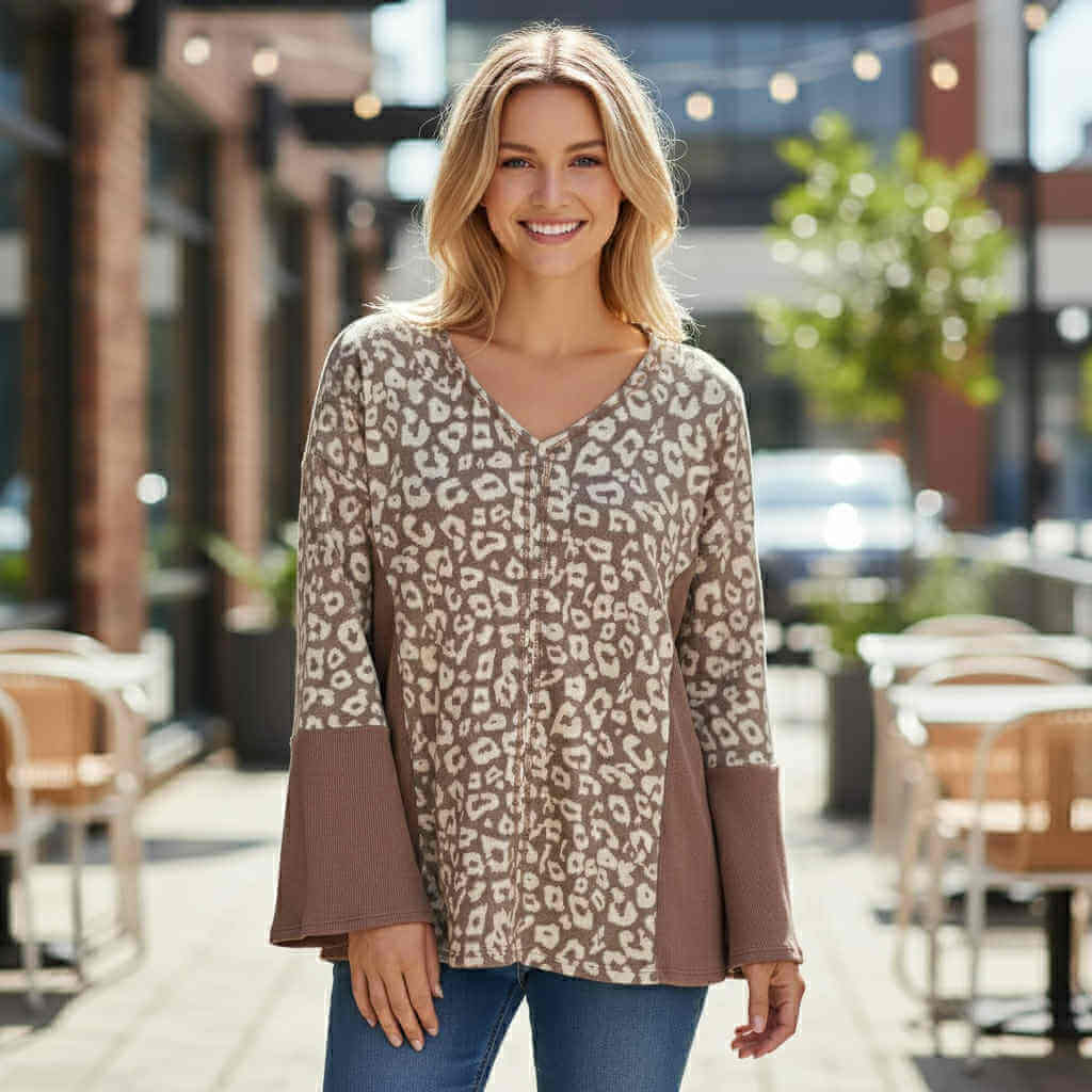 Model wearing UNTAMED SPIRIT TOP (irish mocha) with leopard print panels and bell sleeves.