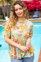 Model wearing an oversized floral peplum drop shoulder knit top by Haptics, vibrant colors, with pool in the background.