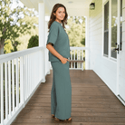 Woman wearing QUIET MOMENTS PANTS SET (ash jade) on a porch, showcasing a stylish, comfortable look.