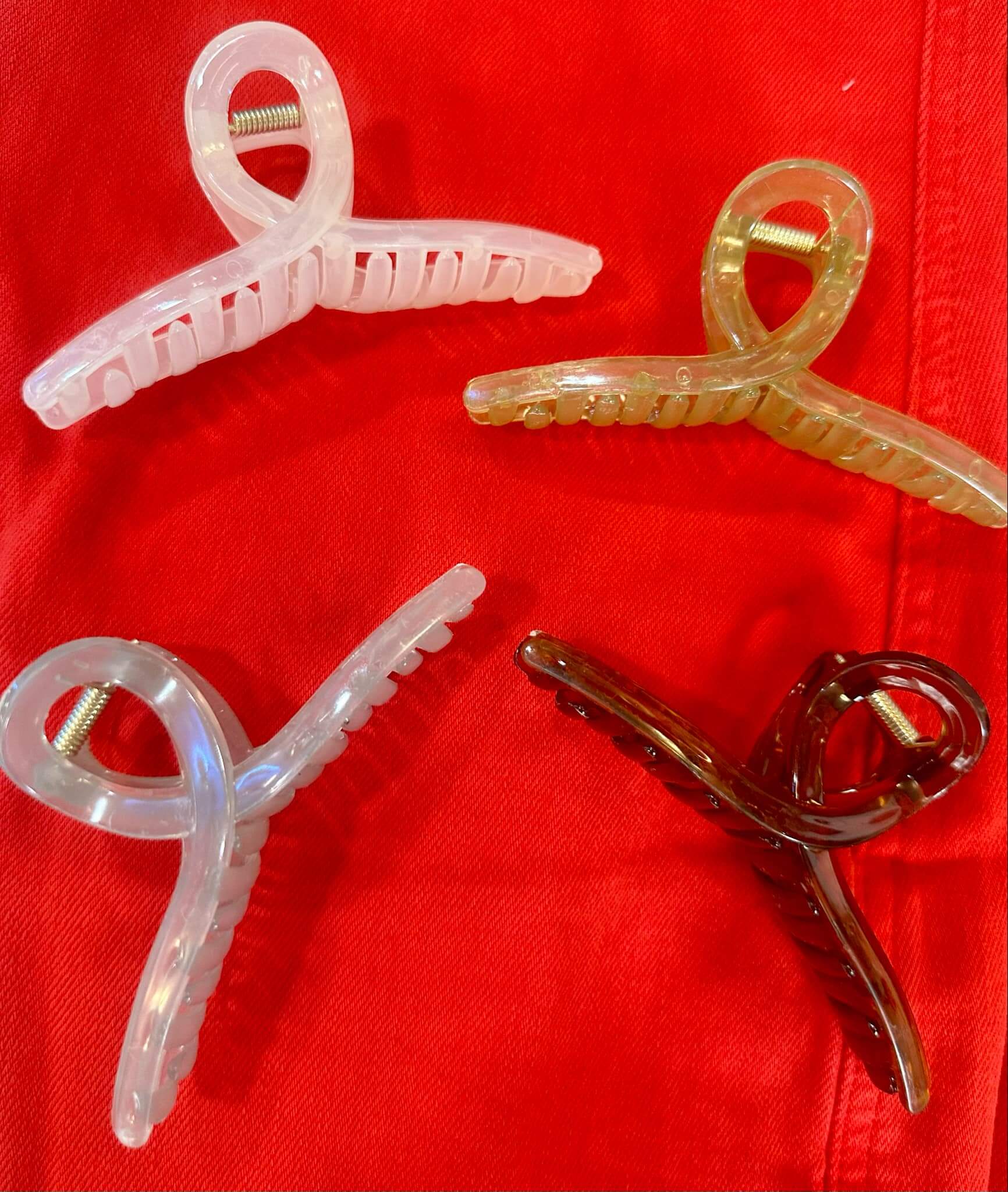 Set of colorful Hold Me Softly hair clips on a red background, featuring translucent jelly design, perfect for thick hair styling.