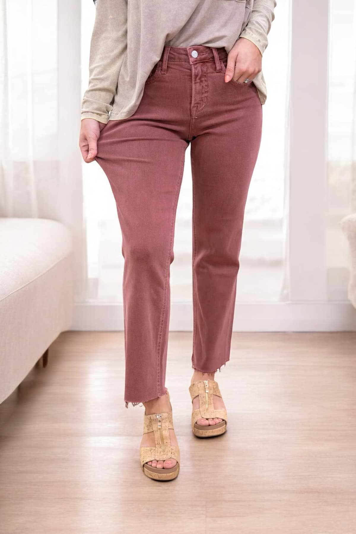 Woman wearing REESE Jeans from Lovervet by Vervet with high-rise waist, cropped length, and raw hem in a stylish indoor setting.