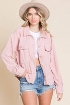 Women's pink embossed shacket with relaxed sleeves, styled with shorts and a hat, perfect for casual wear.