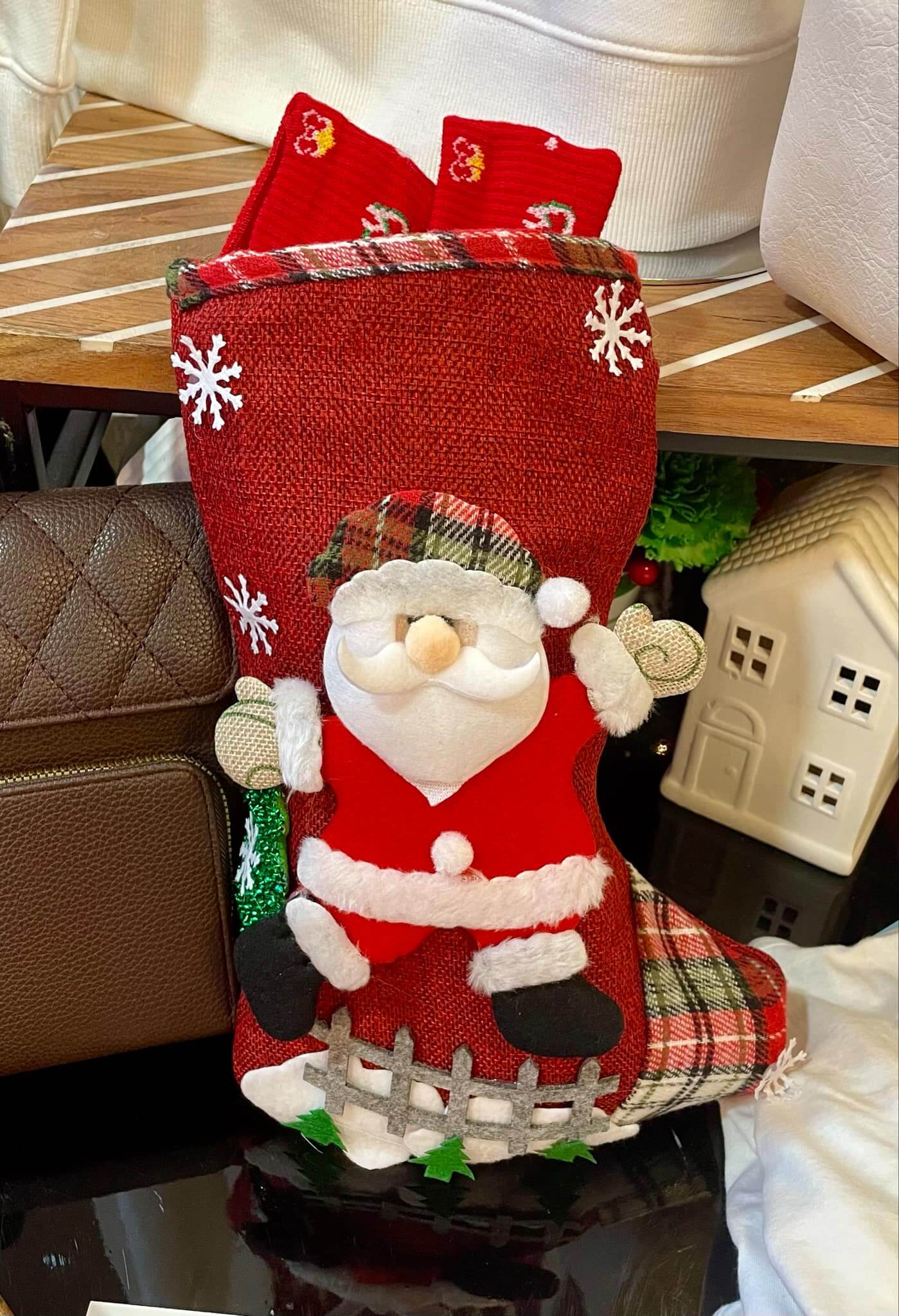 Santa's red burlap stocking adorned with a festive felt Santa and snowy details, filled with gifts and holiday cheer.