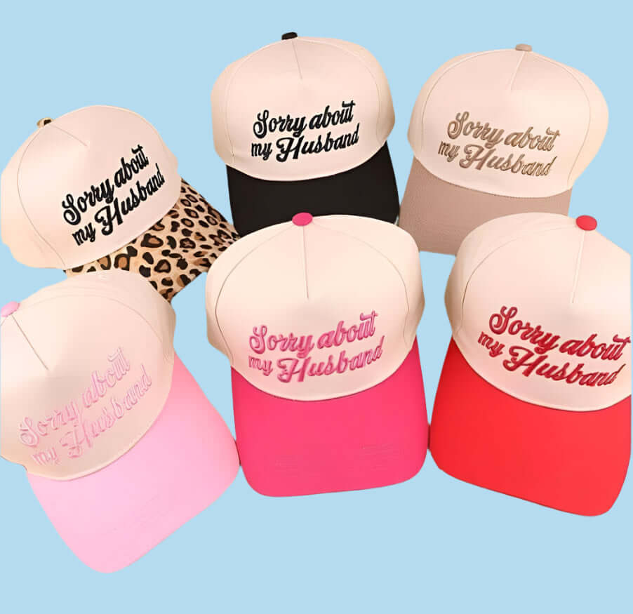 Variety of SORRY ABOUT MY HUSBAND trucker hats in different colors and styles on a light blue background.