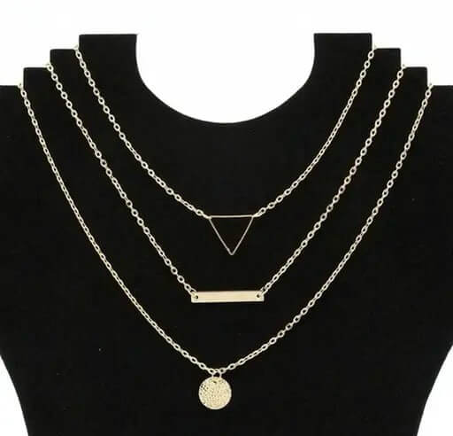 Shapes of Life layered necklace set showcasing triangle, bar, and circle pendants on black display.