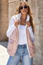 REVERSIBLE RETREAT VEST! Model wearing pink sherpa lined quilted vest with side pockets and sunglasses.