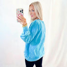 OCEAN MIST PULLOVER in blue mineral wash, featuring a relaxed fit and stylish raw seams, worn casually by a model.
