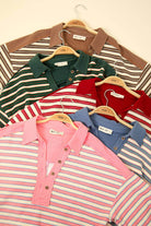 Oversized casual striped knit tops in various colors hanging on hangers for autumn fashion display.