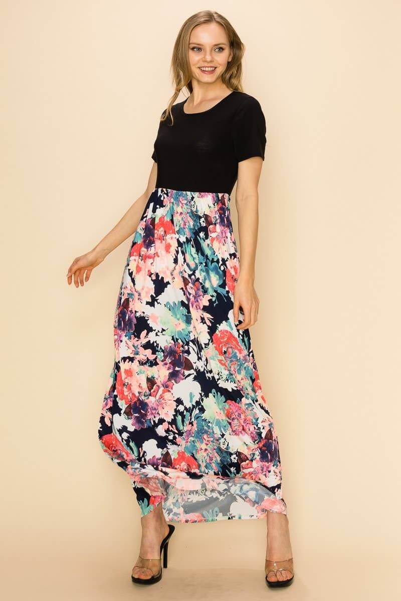 Model wearing the black Raven Radiance Maxi Dress with a vibrant floral skirt, showcasing modern style and feminine charm.