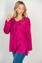 Woman wearing HAPPY WANDERER Top in hot pink by White Birch, featuring V-neck and side split, styled with blue jeans.