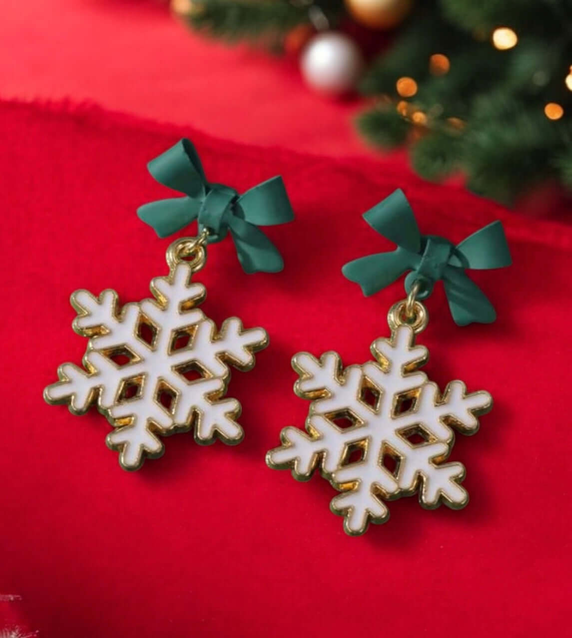 Winter Wonderland Snowflake Earrings with green bows, perfect for holiday outfits and winter celebrations. Size 1.25 x 0.75 inches.