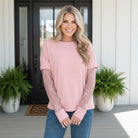 SIMPLY ENCHANTED TOP (pink) model wearing a soft pink top with sheer lace sleeves and relaxed fit, styled casually outdoors.