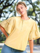 Chic Ruffled Breeze cotton top in vibrant lemon yellow with ruffle sleeves, perfect for pairing with denim.