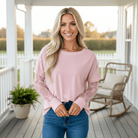 Model wearing the SIMPLY ENCHANTED TOP (pink) with lace mesh sleeves, styled in a casual setting.