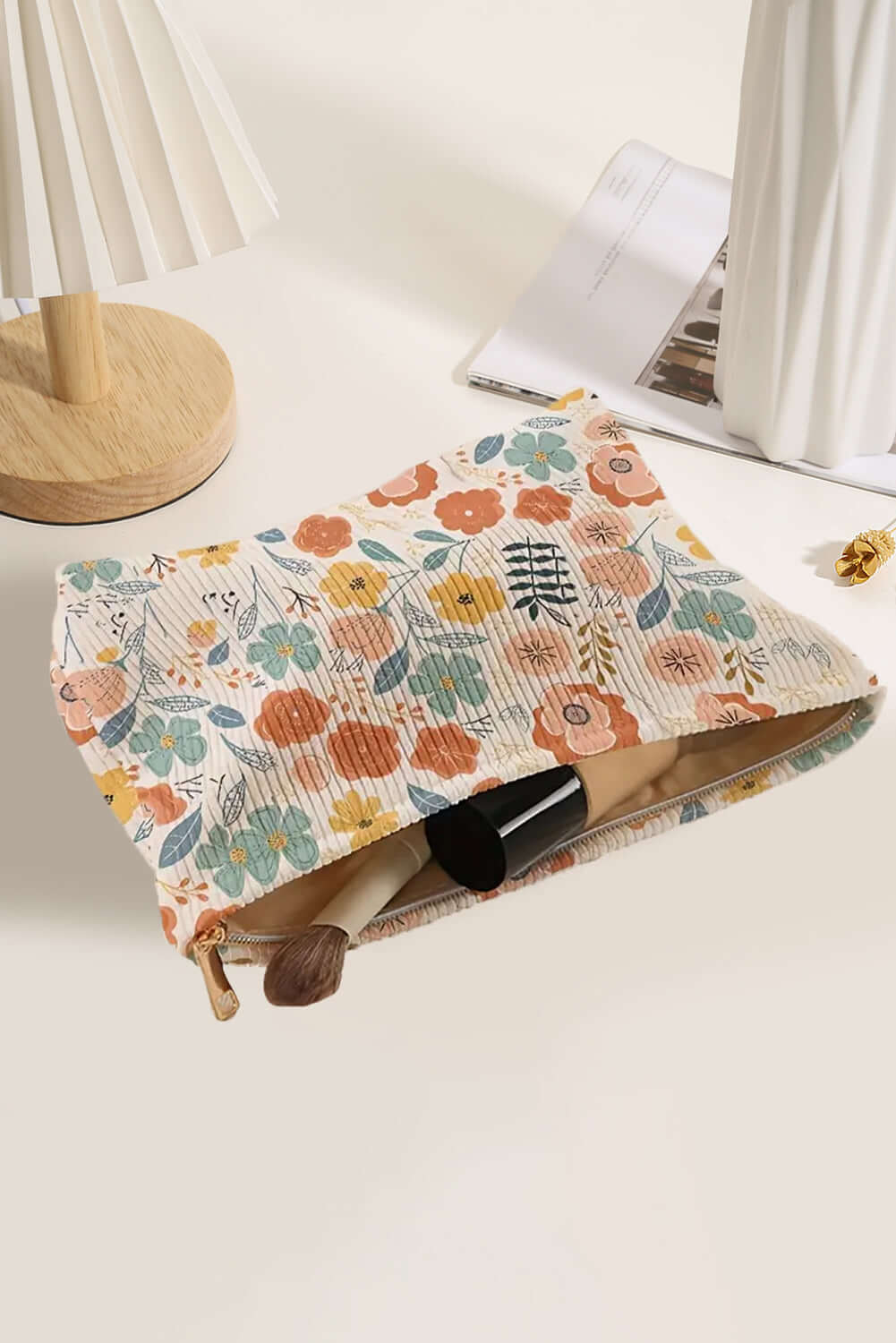 Ivory floral corduroy cosmetic bag with vibrant floral print for travel and everyday use.