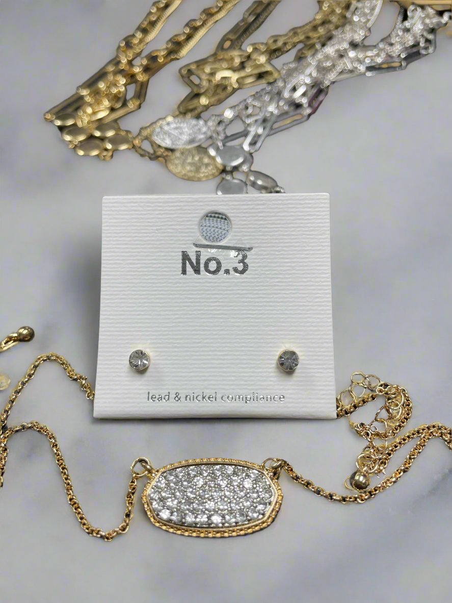 Druzy oval pendant and stud earrings set displayed on a jewelry card, showcasing sparkling stones and gold details.