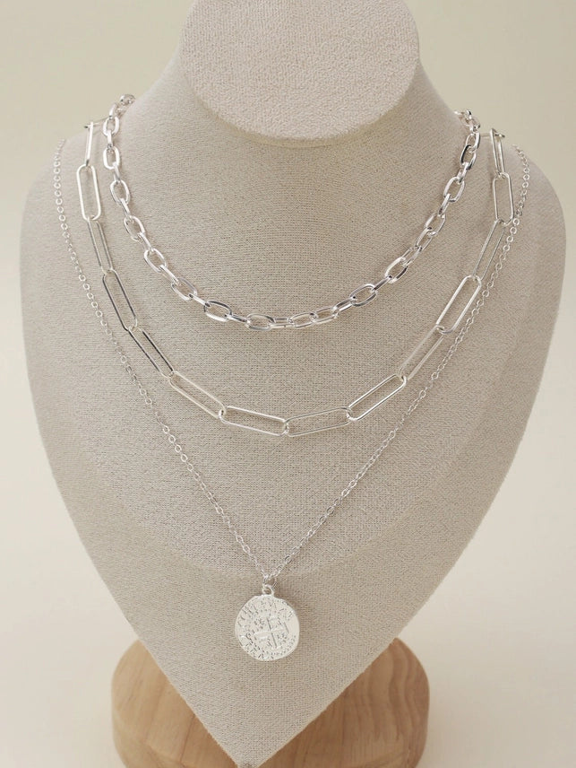 Multi-layer silver chain necklace set with pendant on display bust, elegant and versatile jewelry for accessorizing outfits.