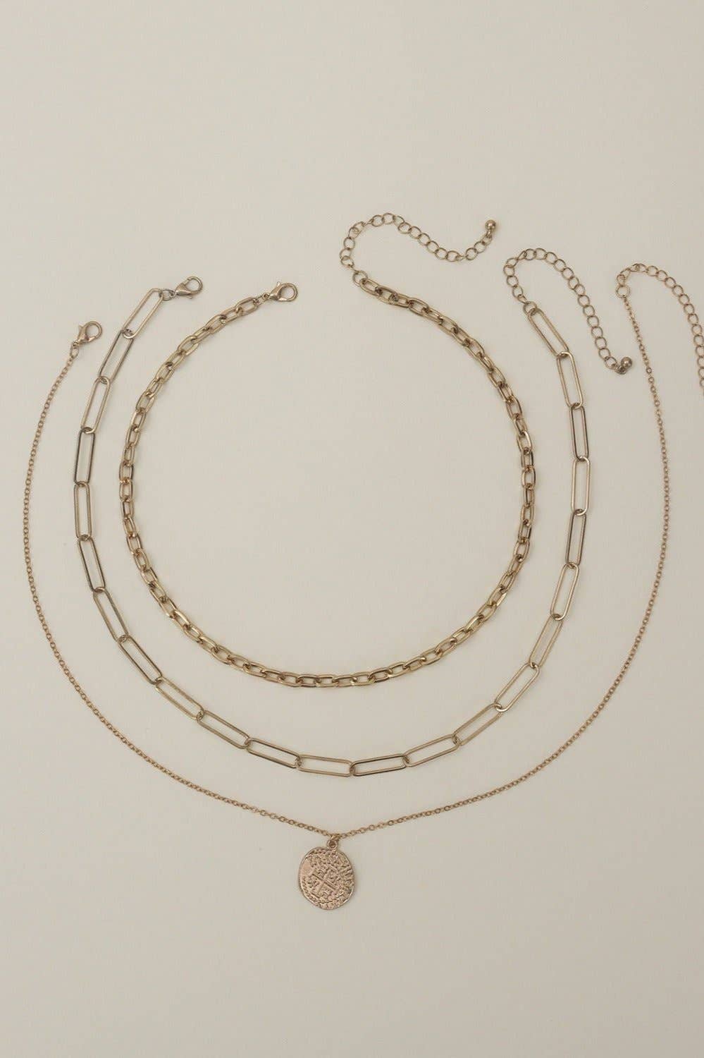 Multi-layer chain necklace set in gold tones featuring three stylish pieces for versatile accessorizing.